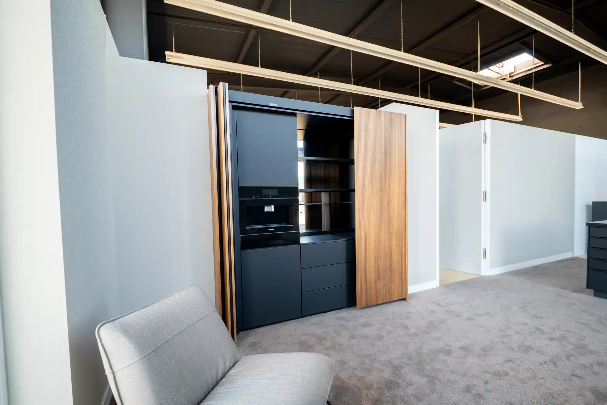 Küche im Schickinger Showroom in Sinzheim – schwarze fronten, holz, teppich
